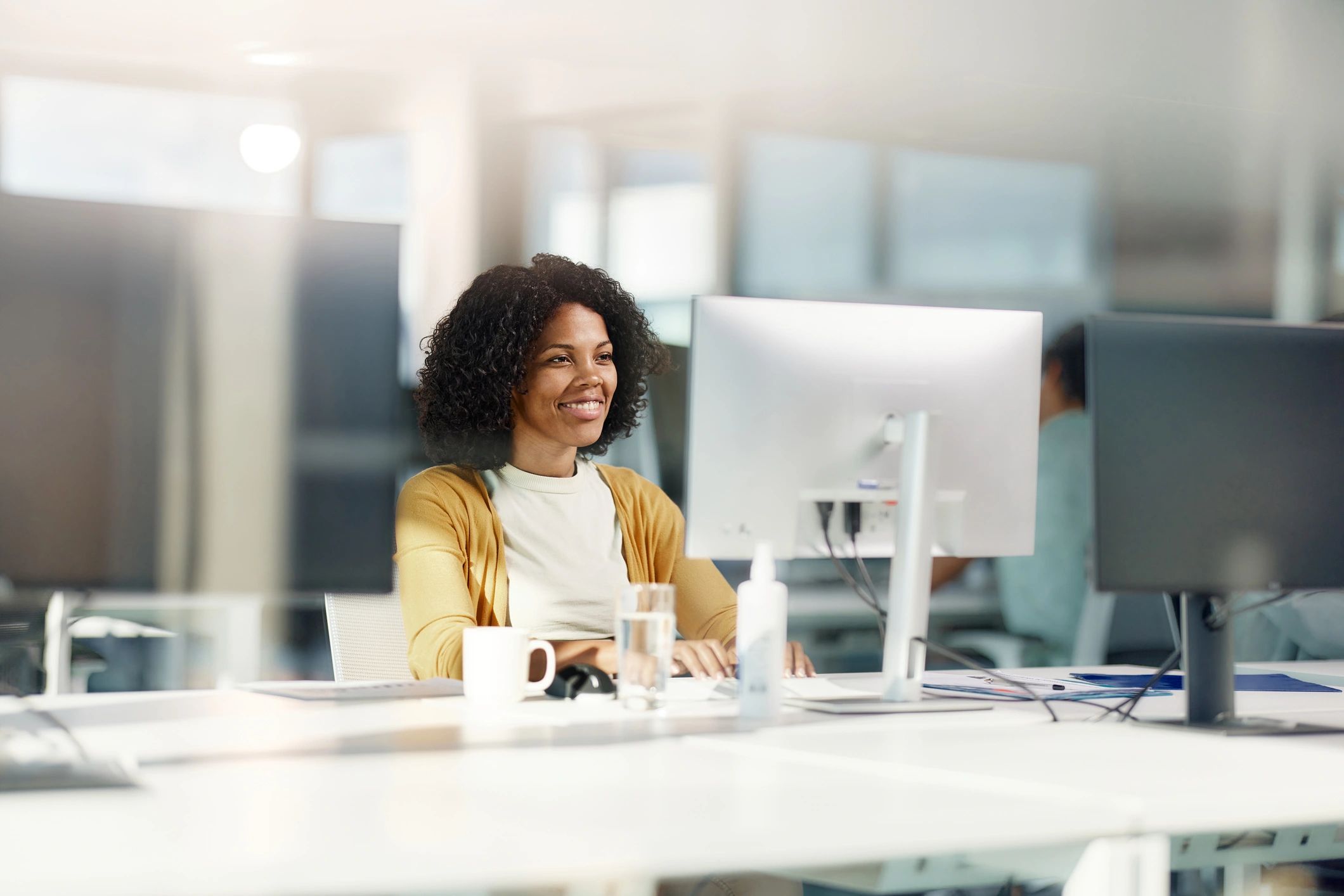 Professional headshot of a businesswoman working at a computer