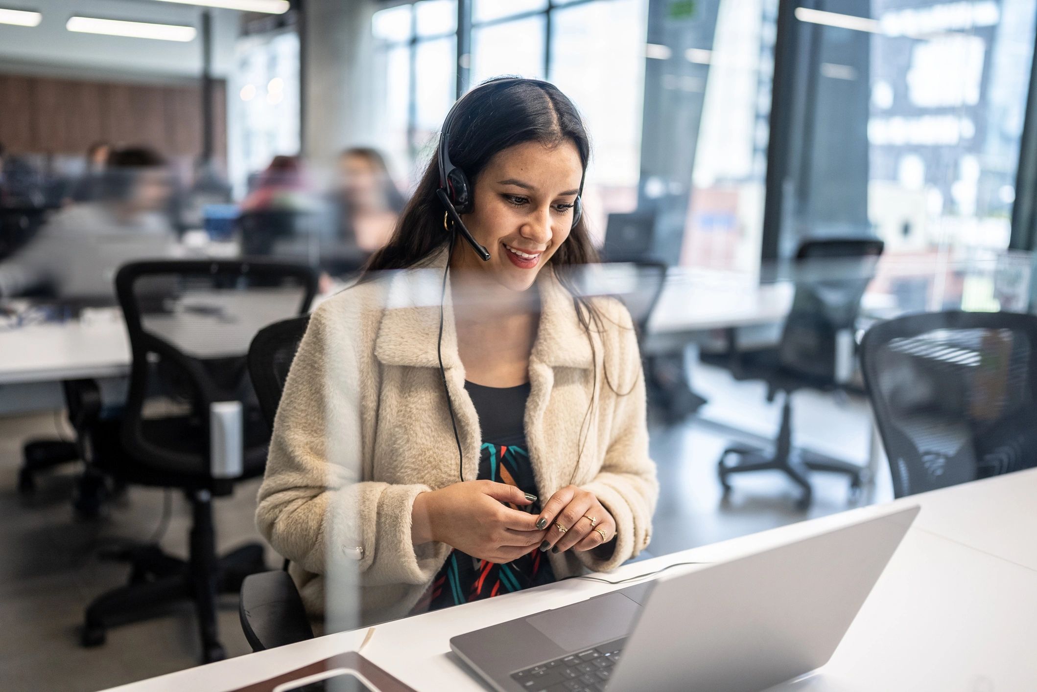 Customer support agent wearing a headset at a desk