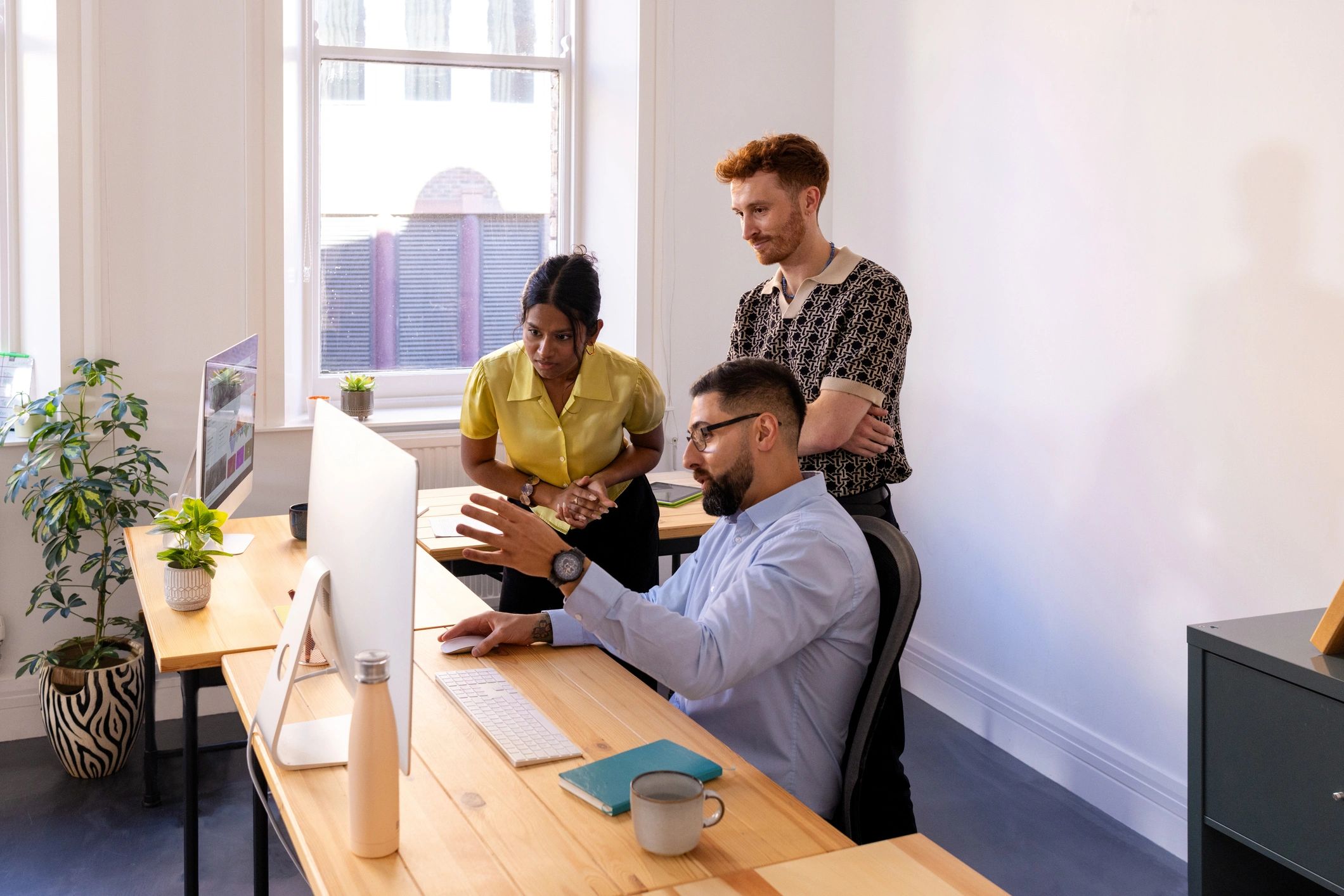 Colleagues reviewing a computer screen during a support discussion