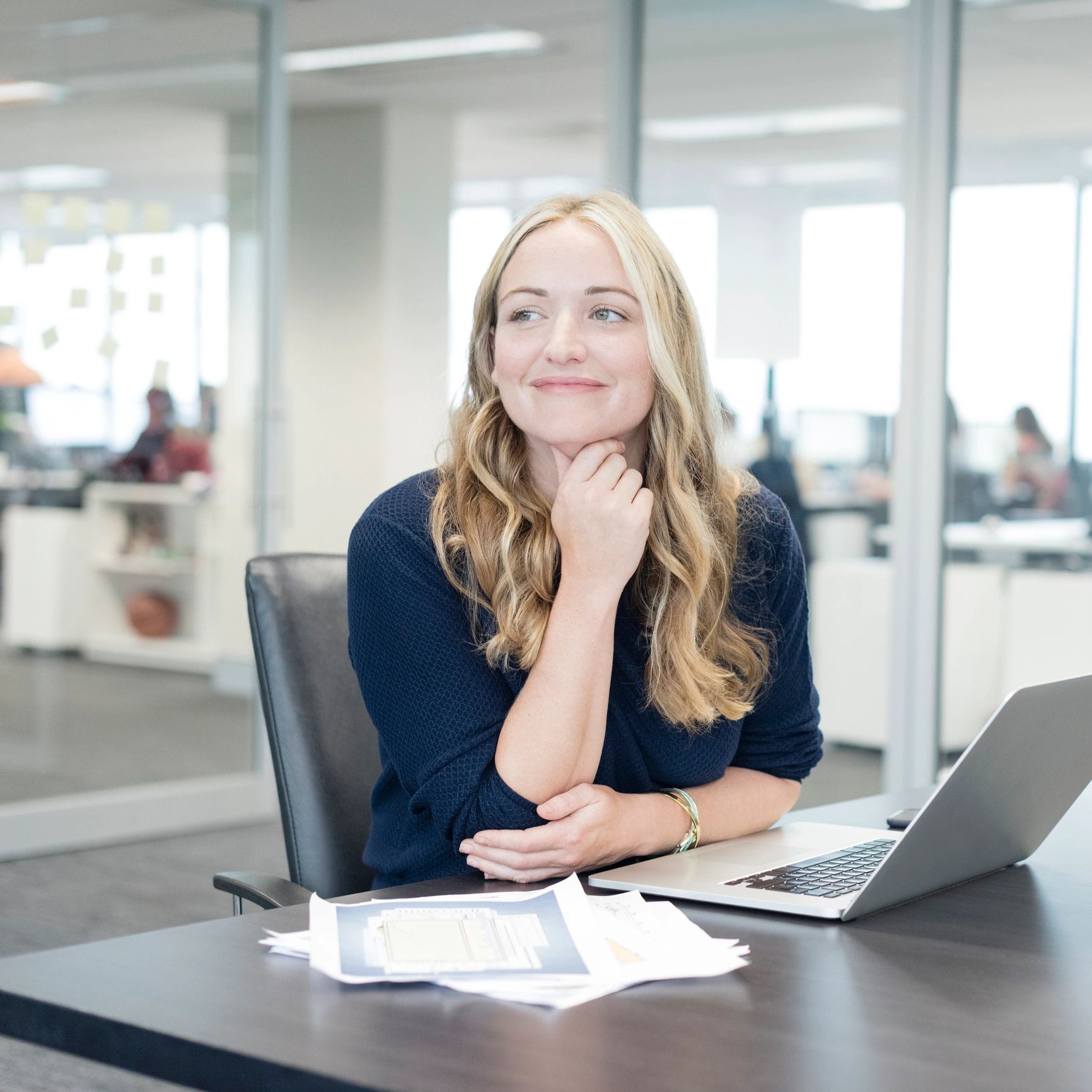 Professional headshot of a smiling businesswoman at a desk